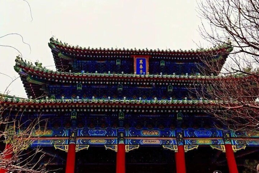A traditional Chinese building with ornate blue and red decorations, a prominent red pillar, and a blue plaque with Chinese characters. 2