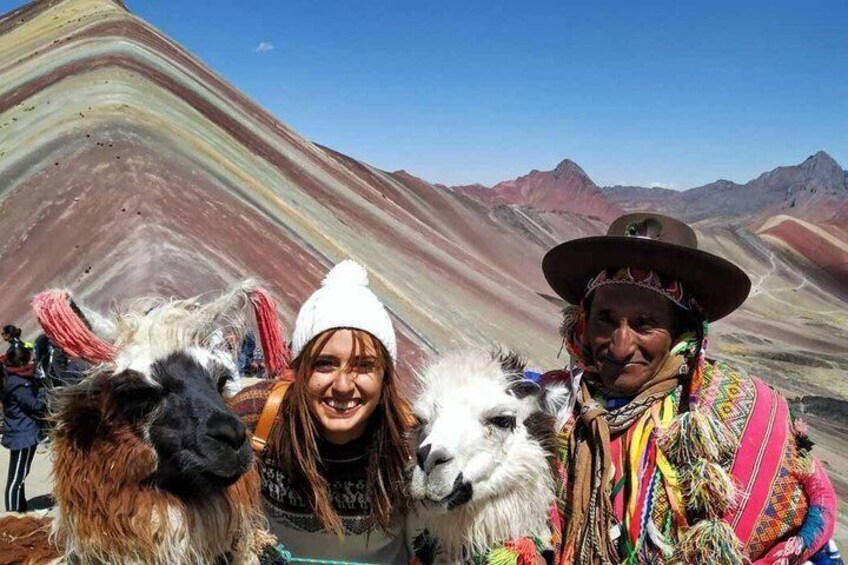 A person in traditional attire with llamas in a colorful landscape. 2