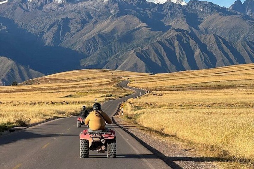 A quad bike on a road with a mountainous landscape in the background. 1