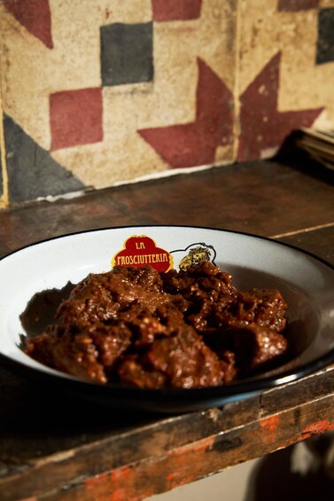 A plate of meat with a label reading 'In Froschuterle.' 5