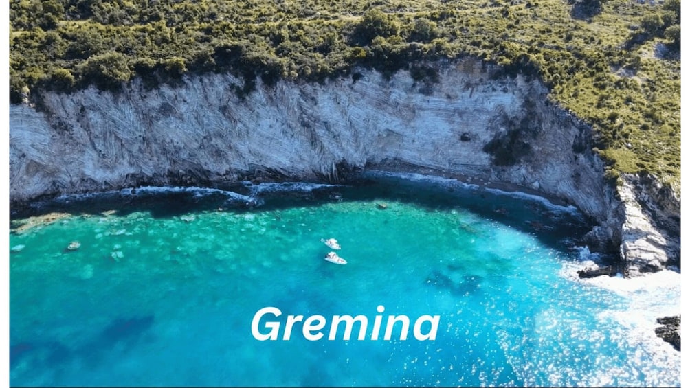 A coastal cliff with clear turquoise waters and the text 'Gremina'. 2