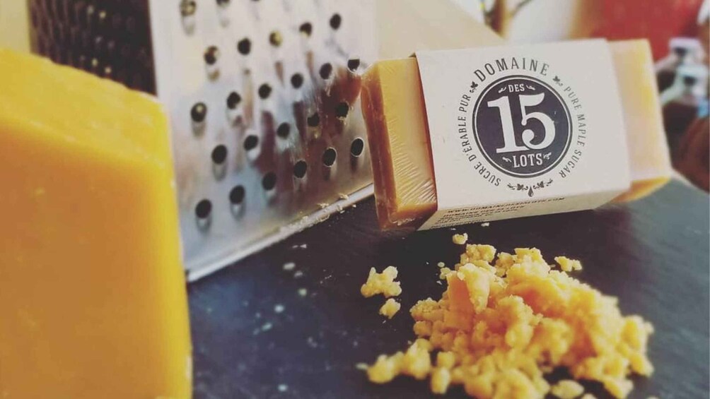 A grater and grated cheese on a dark surface. 5