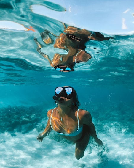 A person swimming underwater in clear blue water. 5