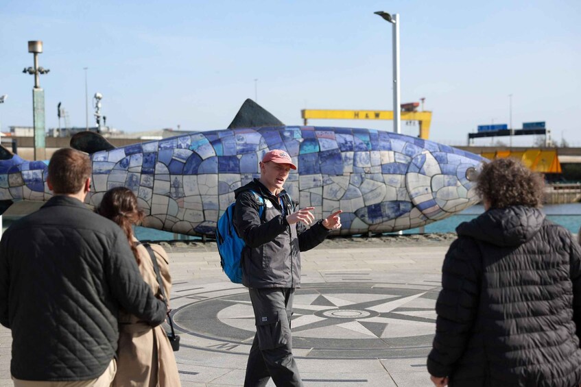 A mosaic structure, a compass design on the ground, and a yellow building in the background. 4