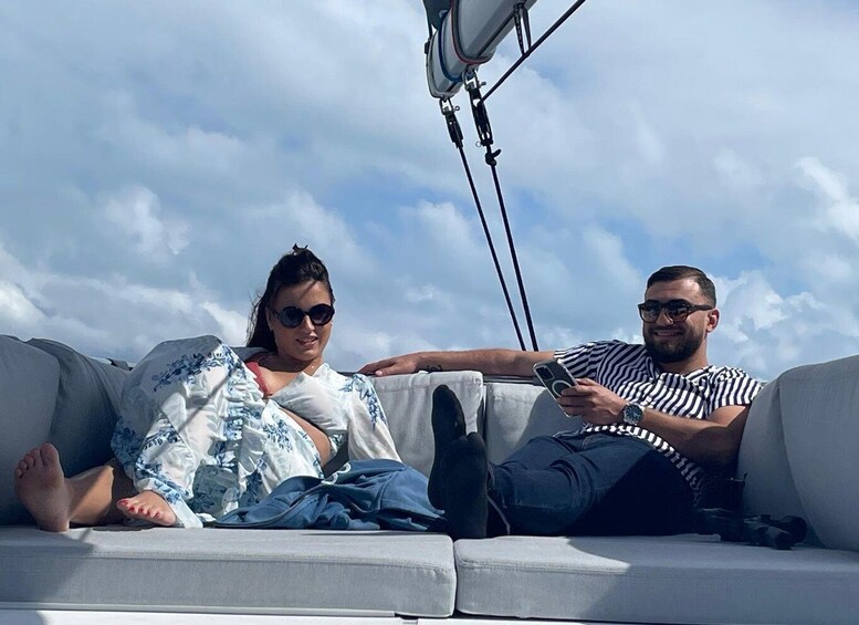 Two people sitting on a couch with a clear sky in the background. 1