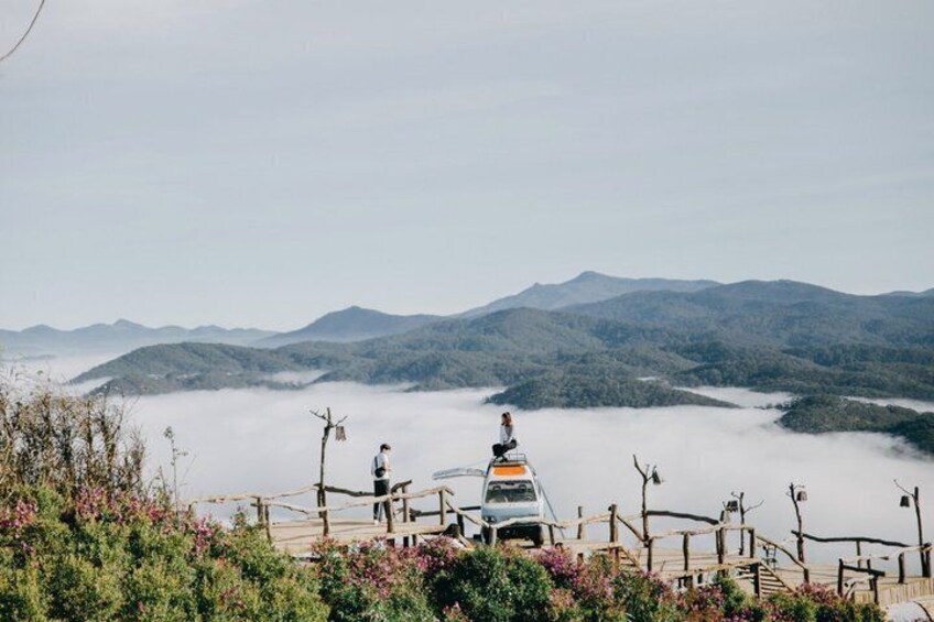 A mountain landscape with a vehicle and a person on a wooden bridge. 3