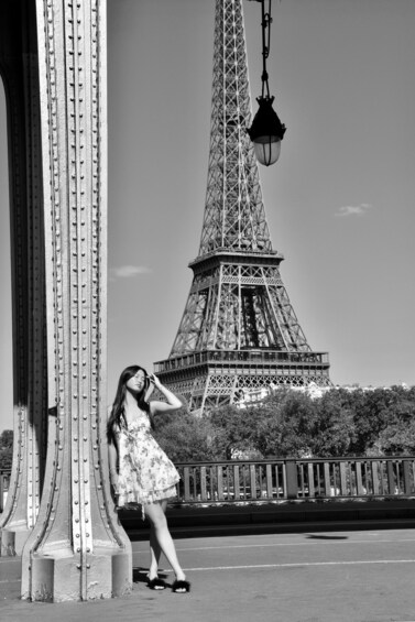A person standing near a bridge with the Eiffel Tower in the background. 4