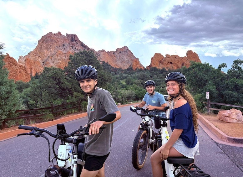 Three people on bicycles with a mountainous landscape in the background. 3