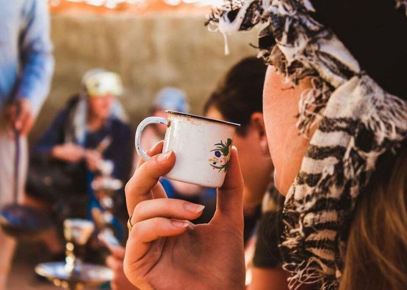 A person holding a mug with a floral design. 3