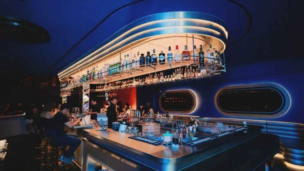 A bar with a curved counter and shelves of bottles. 5
