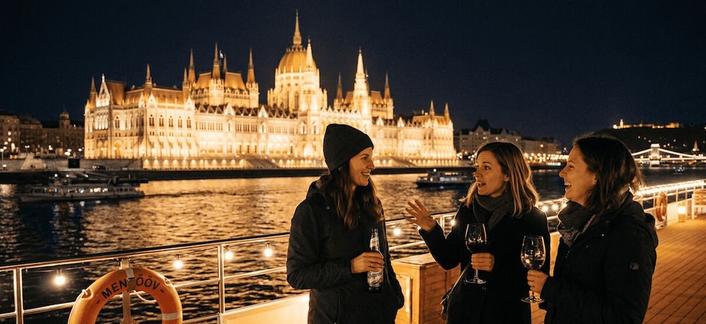 Three people on a boat with a cityscape and a large building in the background. 2