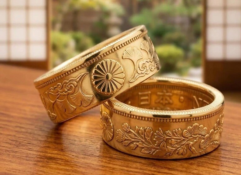 A gold ring with floral engravings on a wooden surface. 1