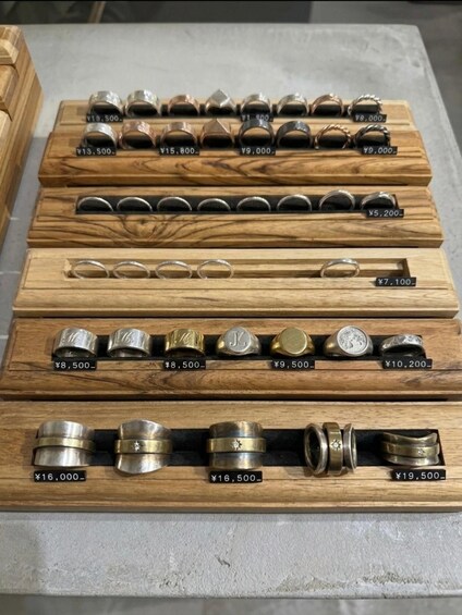 A display of rings in wooden boxes with price tags. 3