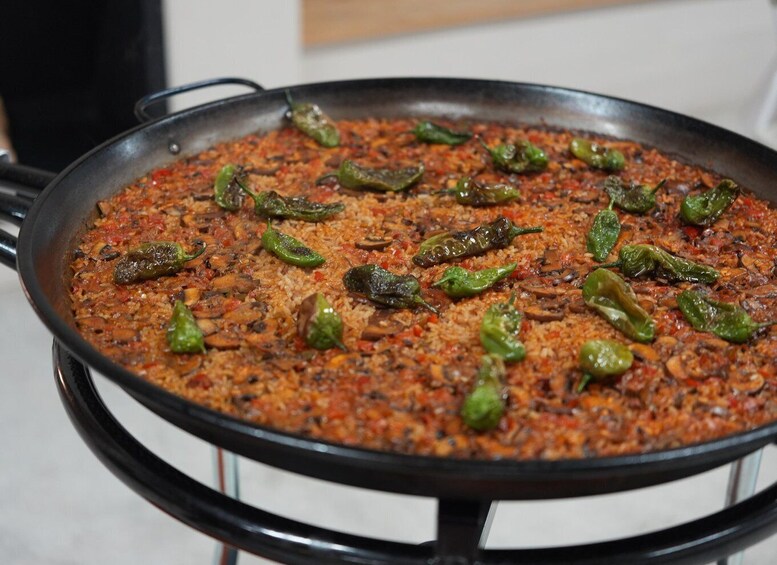 A large pan filled with a dish that includes rice, green peppers, and a red sauce. 3