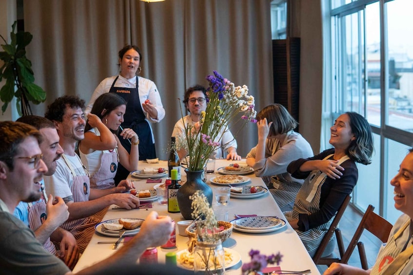 A group of people dining at a table with a chef standing behind them. 4