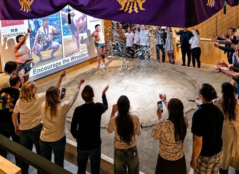A crowd watching a wrestling event with a banner that reads 'Encourage the Wrestlers.' 4