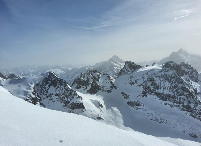 A snow-covered mountain range with sharp peaks and a clear sky. 2
