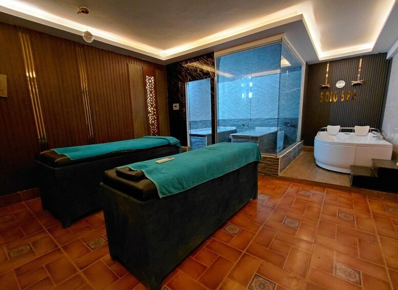 A spa room with massage tables, a glass-enclosed area with a view, and a reception desk. 3
