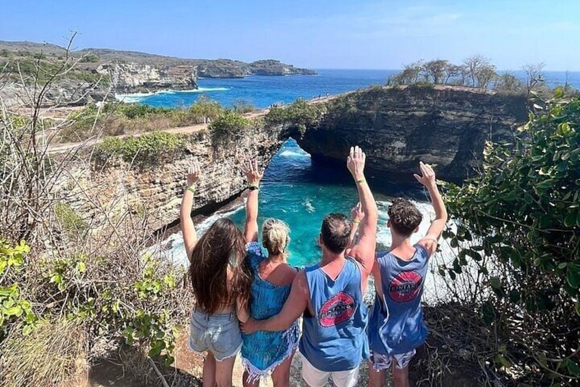 A group of people overlooking a coastal cliff with a view of the ocean. 1