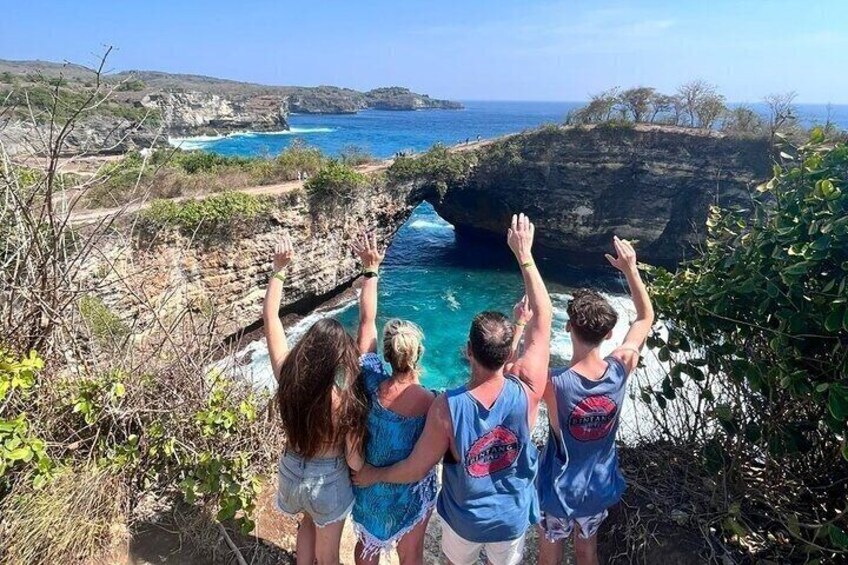 A group of people overlooking a coastal cliff with a view of the ocean. 1