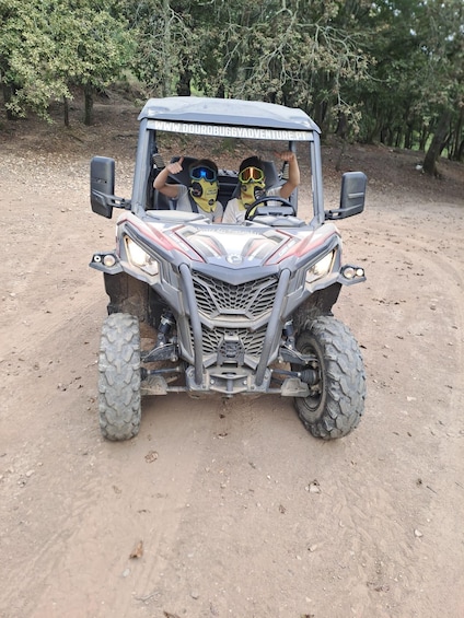 A four-wheeled vehicle on a dirt path with trees in the background. 3