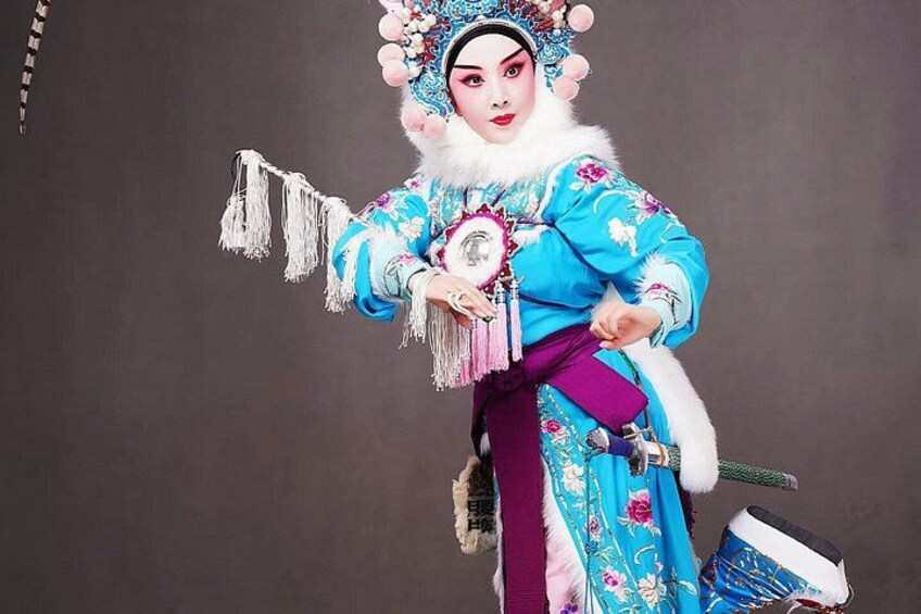 A person in traditional blue and purple costume with a fan and a sword. 4