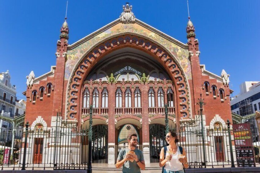 A historic building with ornate arches and a red facade. 4