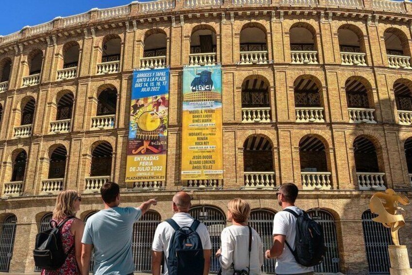 A historic building with arched windows and a central balcony, featuring multiple banners advertising events. 3