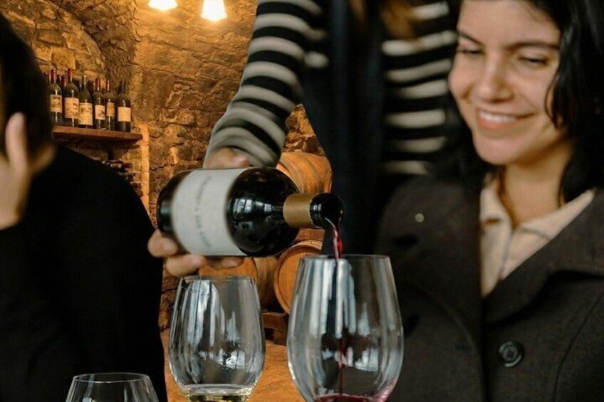 A person pouring wine into a glass. 3