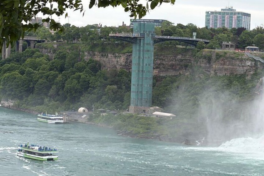 A river with a boat, a waterfall, a bridge, and a building on a cliff. 4