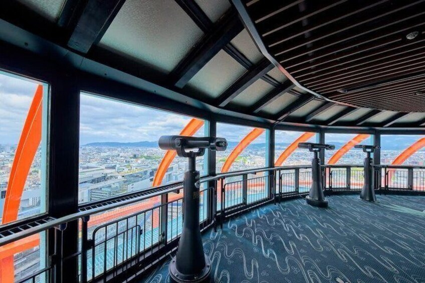 A panoramic view from a high vantage point, featuring a cityscape and a bridge with orange arches. 3