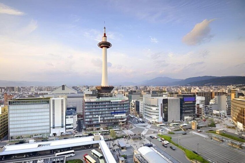 A cityscape with a prominent tower, modern buildings, and a clear sky. 5