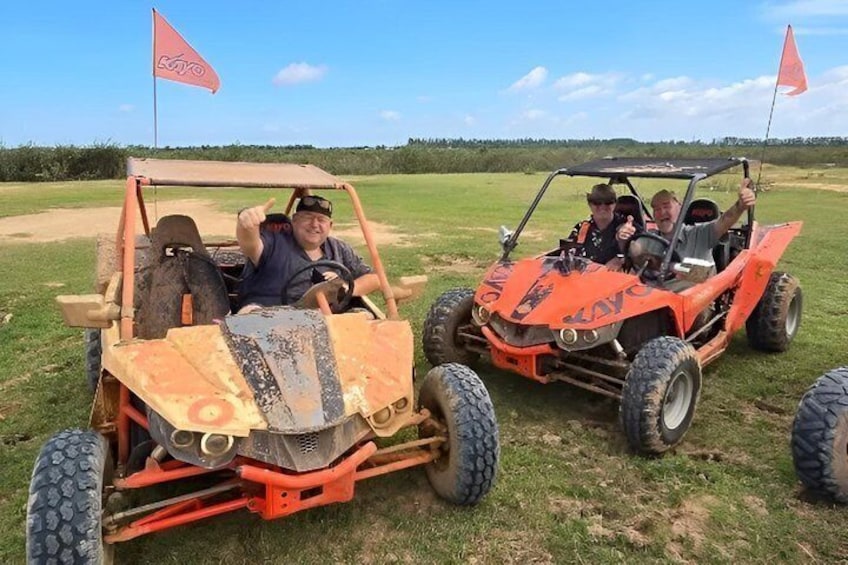 Two orange off-road vehicles on a grassy field with a clear sky. 3