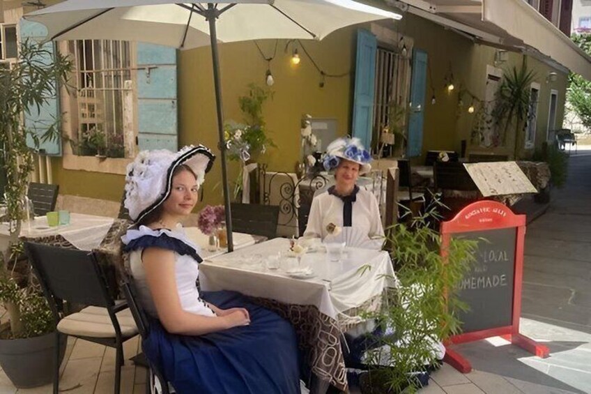 Two people seated at an outdoor table with a menu stand nearby. 3
