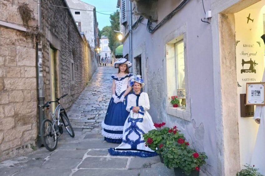 A narrow street with cobblestones, a bicycle, and a shop with a signboard. 2