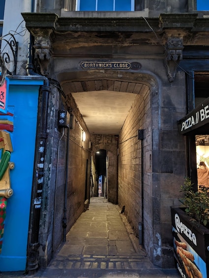 Kapea kujanne, jossa on kyltti, jossa lukee ”Borthwick’s Close”, ja pizzaravintolan sisäänkäynti. 2