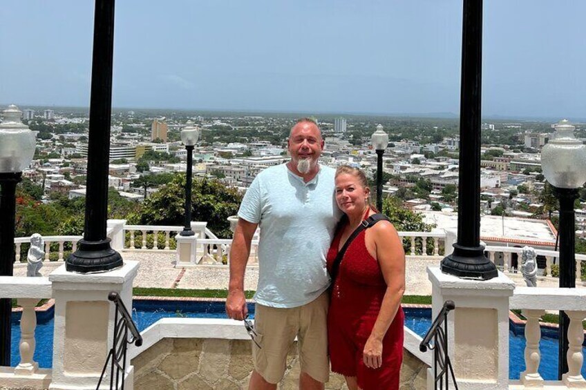 A man and woman standing by a pool with a cityscape in the background. 2