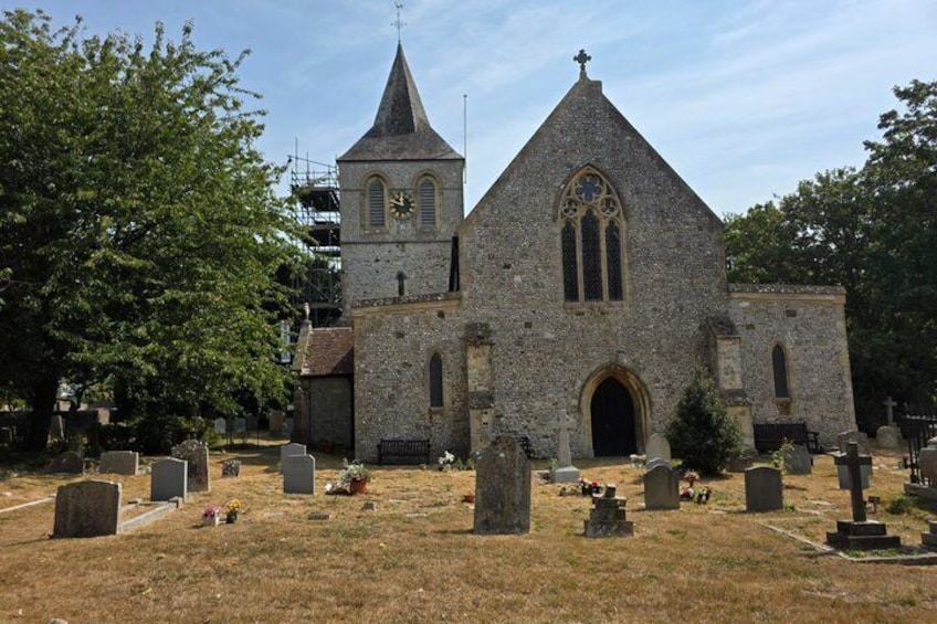 A church with a steeple and a graveyard in front. 5