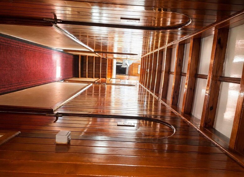 A wooden interior with a curved ceiling and a red wall. 1