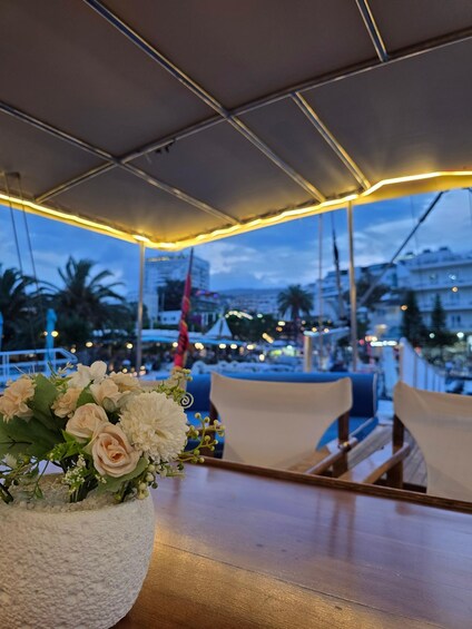 A table with a floral arrangement and a view of a cityscape at dusk. 3