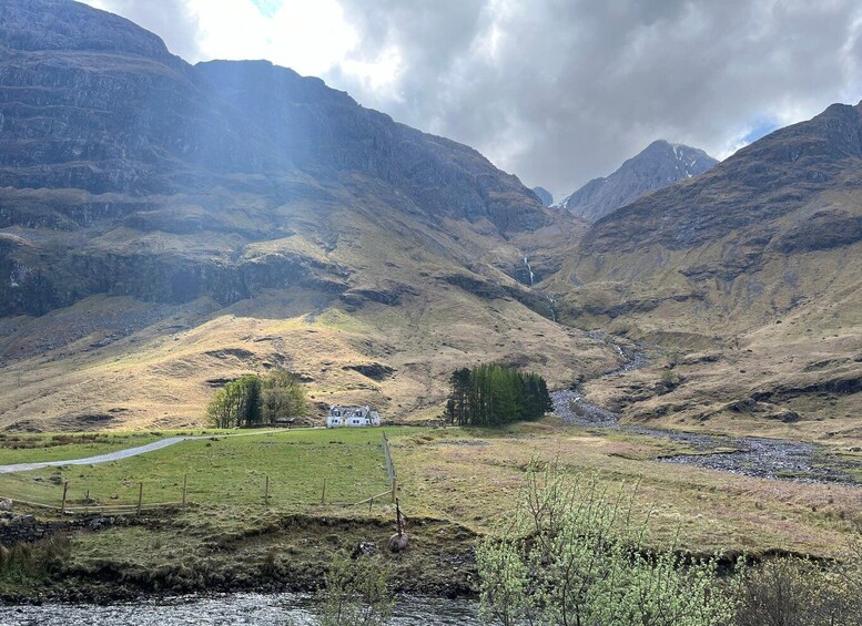 A mountainous landscape with a house, a river, and a path. 3