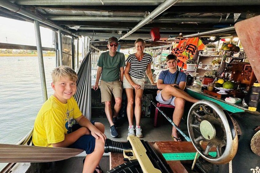 A group of people on a boat with a water wheel and a market stall. 3