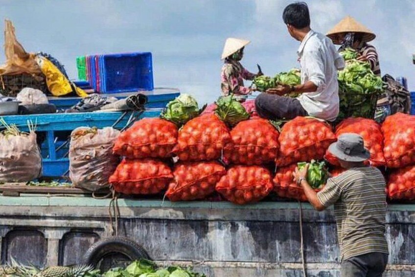 People loading bags of produce onto a boat. 2