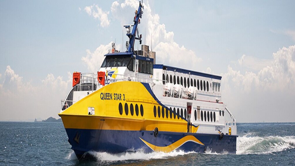 A large, yellow and blue ferry named 'Queen Star 3' moving through the water. 1