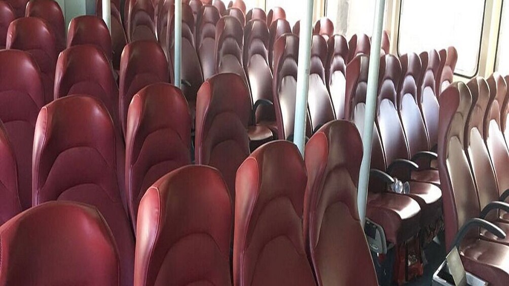 Rows of red seats in a bus interior. 5
