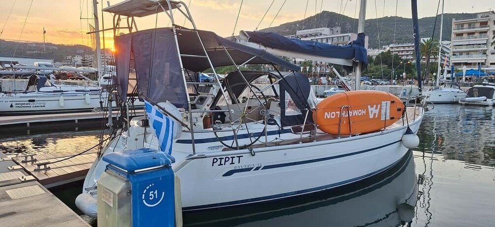 A boat named 'PIPIT' docked at a marina with other boats, a lifebuoy, and a blue waste bin. 4