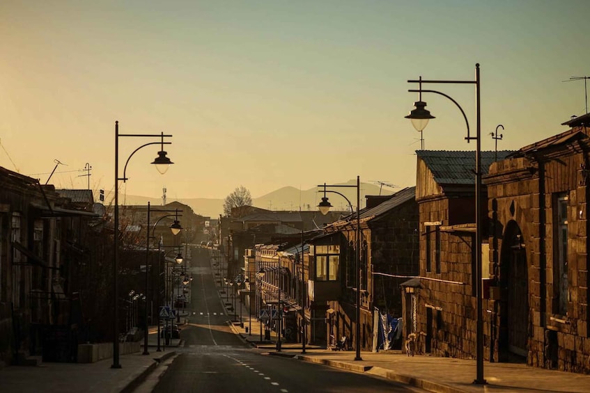 Eine ruhige Straße, gesäumt von historischen Gebäuden und Straßenlaternen, im Abendlicht. 2