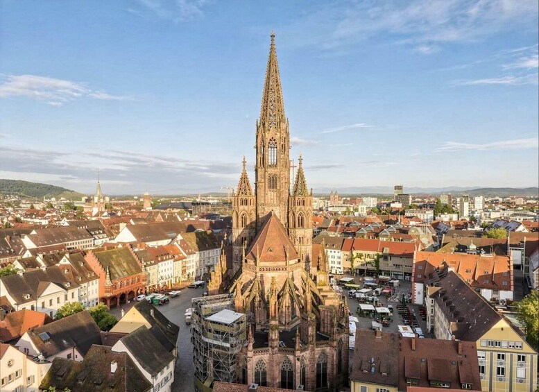 A cathedral with a tall spire, surrounded by a cityscape with historic buildings. 1