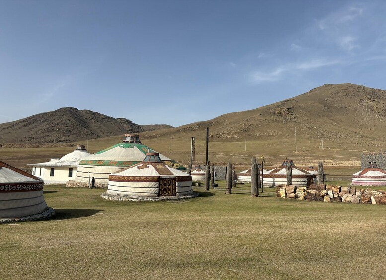 A yurt settlement with a mountainous backdrop. 3