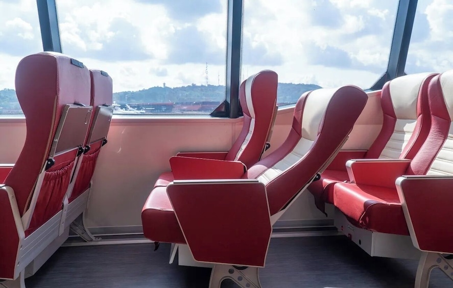 Rows of red and white airplane seats with a view of a cityscape through the window. 5